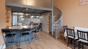 A modern kitchen with a central island, stainless steel appliances, and a spiral staircase. - Royal Mile Mansions by Edinburgh City Apartments (Edinburgh)