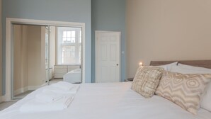 A bedroom with a bed, pillows, and a door. - Royal Mile Mansions by Edinburgh City Apartments (Edinburgh)