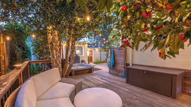 An outdoor patio with a hot tub, seating area, and wooden deck. - Heart of the River~Guerneville 5-Star~Easy Walk to River~HotTub~Dog~SummerFun (Guerneville)