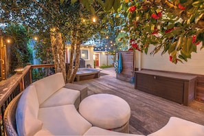 An outdoor patio with a hot tub, seating area, and wooden deck. - Guerneville~Walk to Russian River~Hot Tub~Yoga Studio~Dog OK!~Heart of River (Guerneville)