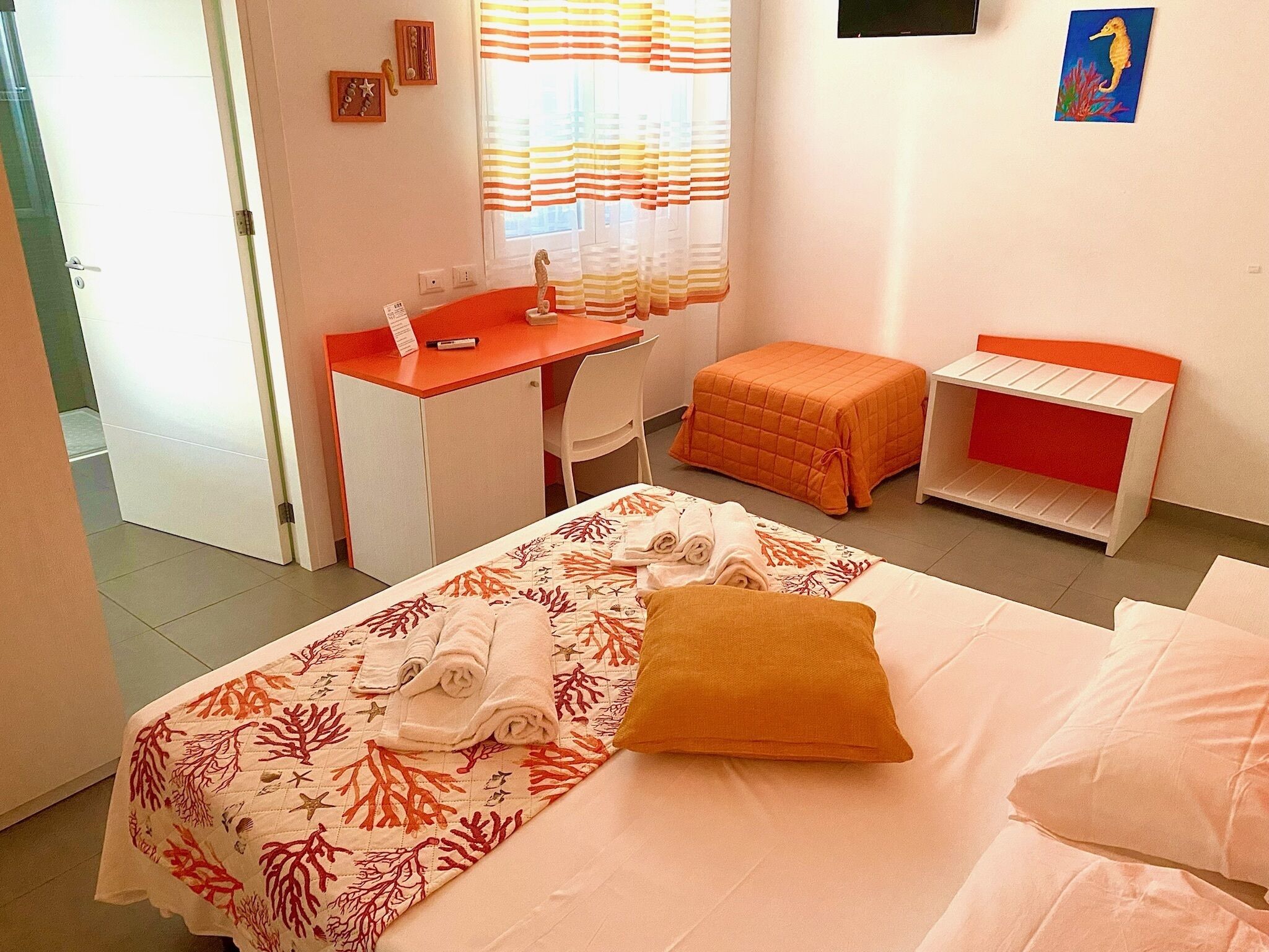 A bedroom with a bed, a desk, and a chair.