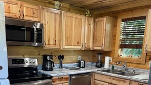 A kitchen with wooden cabinets, stainless steel appliances, and a dining table with placemats.