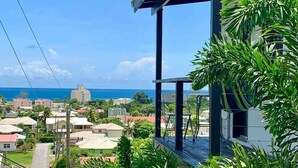 Un quartiere residenziale con vista sull'oceano, caratterizzato da case, un gazebo e una vegetazione rigogliosa.