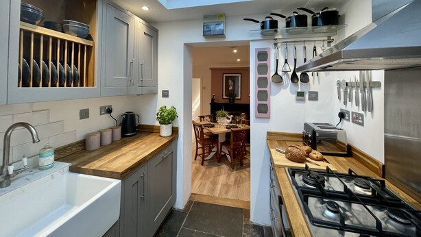 Een moderne keuken met dakraam, een eethoek en uitzicht op de eetkamer.