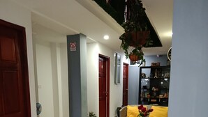 Un salón con muebles de mimbre, un sofá amarillo y una estantería.