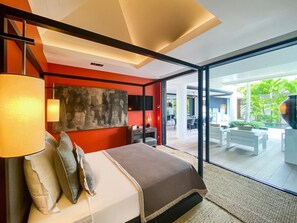 Une chambre moderne avec un grand lit, un tableau au mur et une vue sur la terrasse extérieure.