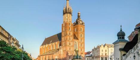A historic cathedral with twin towers, a large open square, and surrounding buildings.