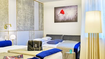 Una habitación de hotel con una cama, mesitas de noche, una lámpara, un cuadro y una maleta.