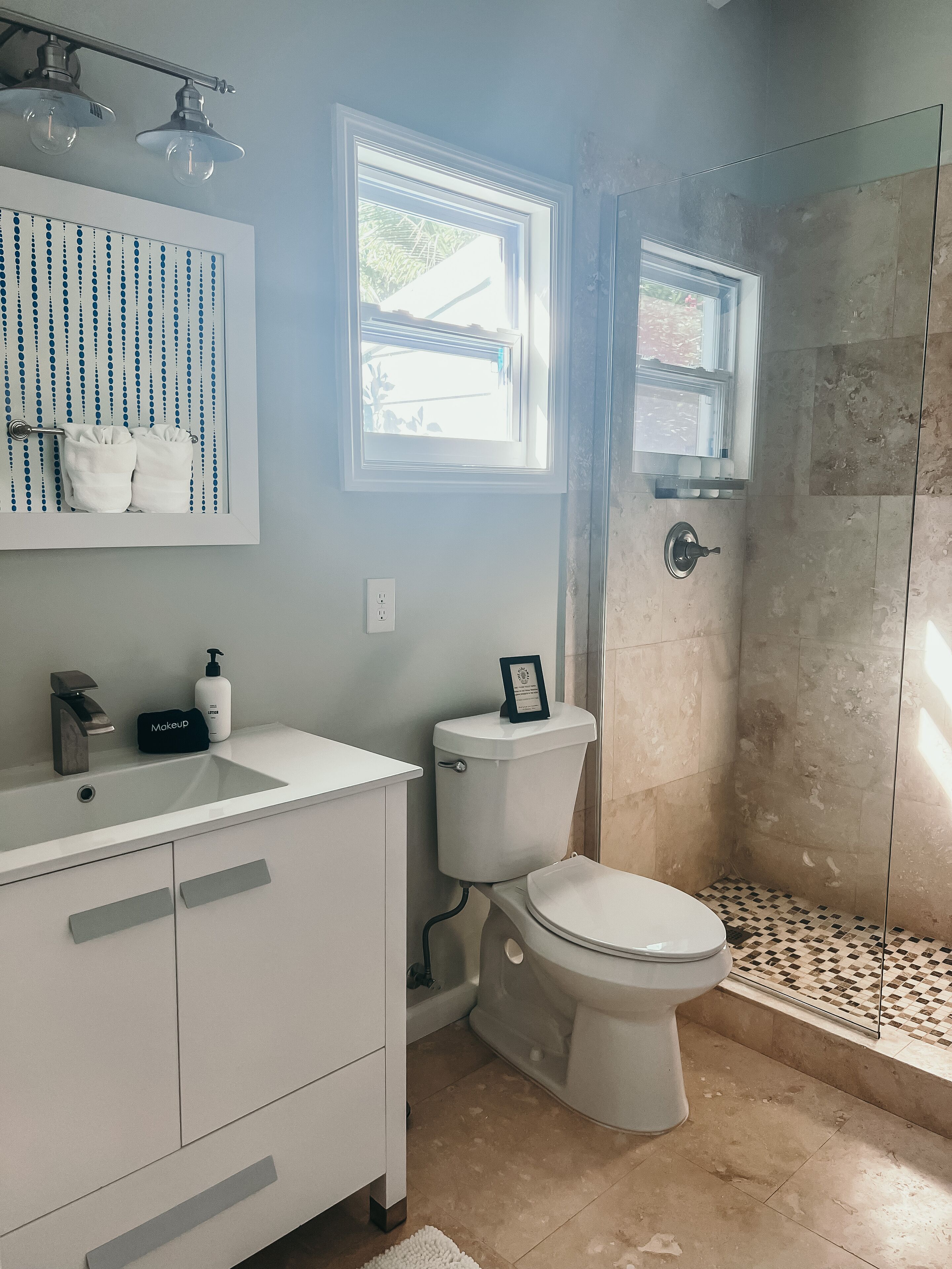 Une salle de bain moderne avec un meuble-lavabo blanc, des toilettes et un espace douche.