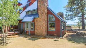 A two-story house with a stone chimney, large windows, and a metal roof. - Perfect Family Vacation Getaway! (Pagosa Springs)