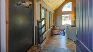 A hallway with a dark door, wooden steps, a bench, and a sofa. - Perfect Family Vacation Getaway! (Pagosa Springs)
