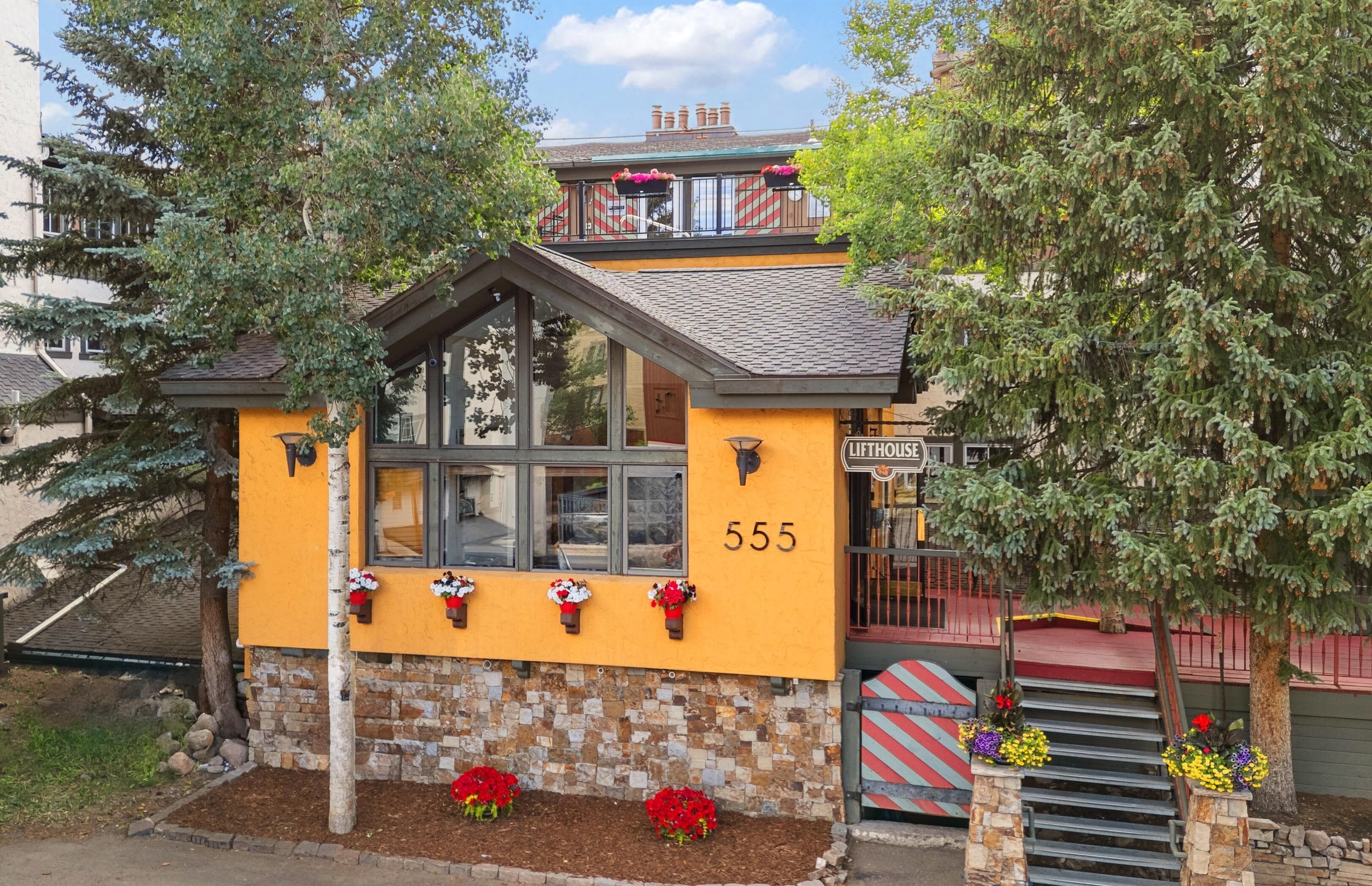 Un bâtiment jaune avec une enseigne indiquant « LIFTHOUSE 555 » et un escalier menant à un balcon.