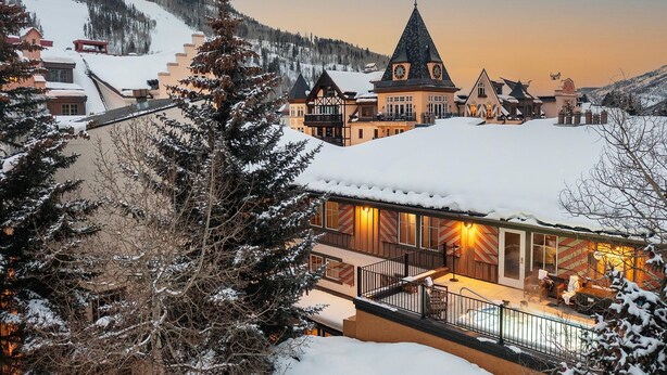 A snow-covered hotel with a prominent tower, a pool area, and a view of the surrounding snowy landscape. - Lift House Lodge, Pet Friendly Studio Condo (Vail)