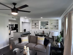 A modern living room with a grey sofa, a coffee table, and a ceiling fan. - GP36B | G. Prairie Condo | 3BD | Pool | Workspace (Grand Prairie)