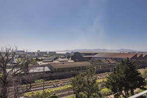 A railway station with multiple tracks and buildings in the background. - Homely Studio Apartment in Cape Town (Cape Town)