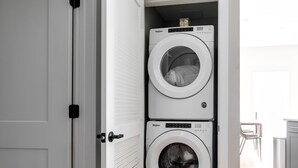 Una lavandería con dos lavadoras Whirlpool apiladas.