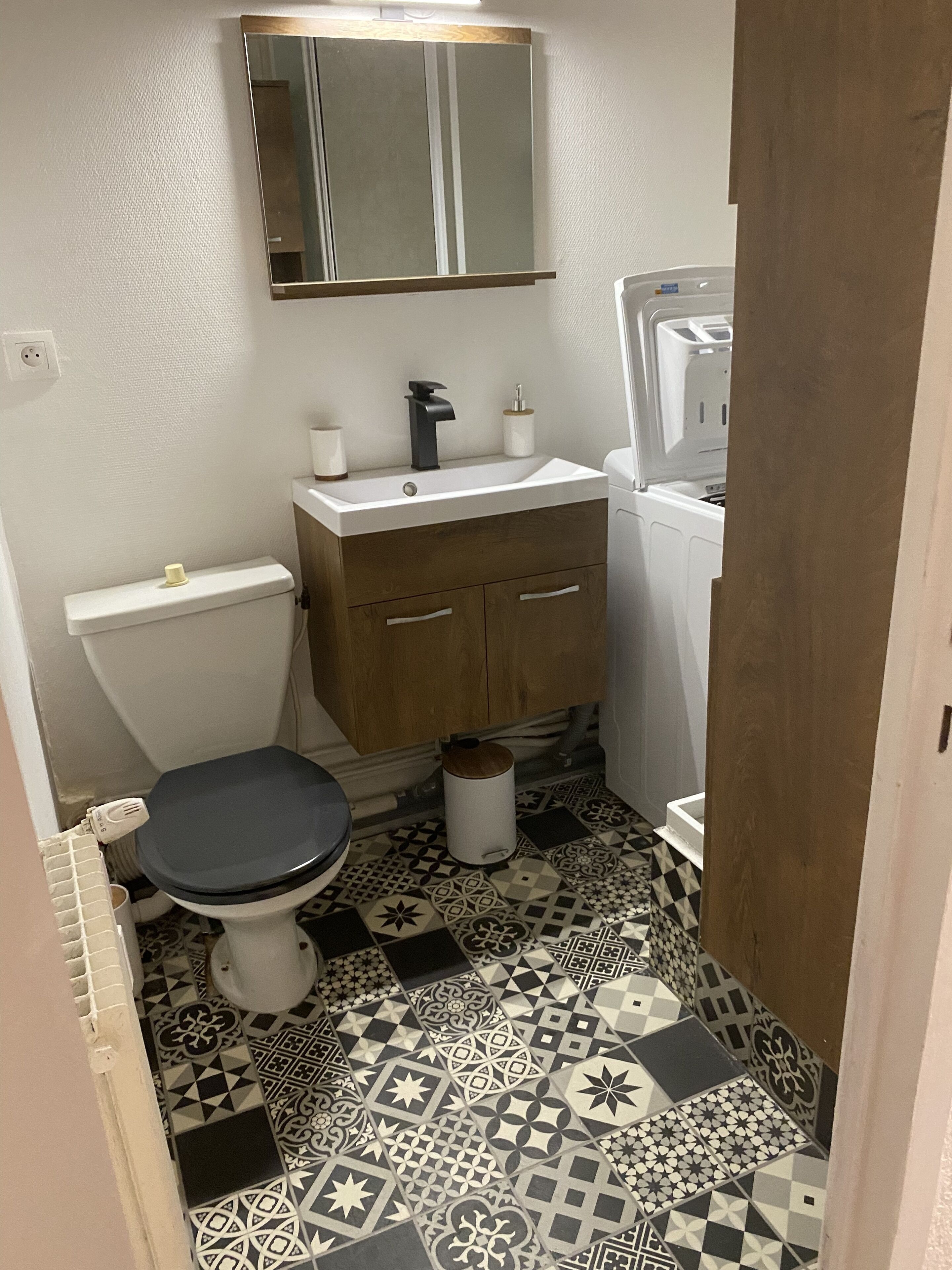 Ein kleines Badezimmer mit Toilette, Waschbecken und Spiegel.