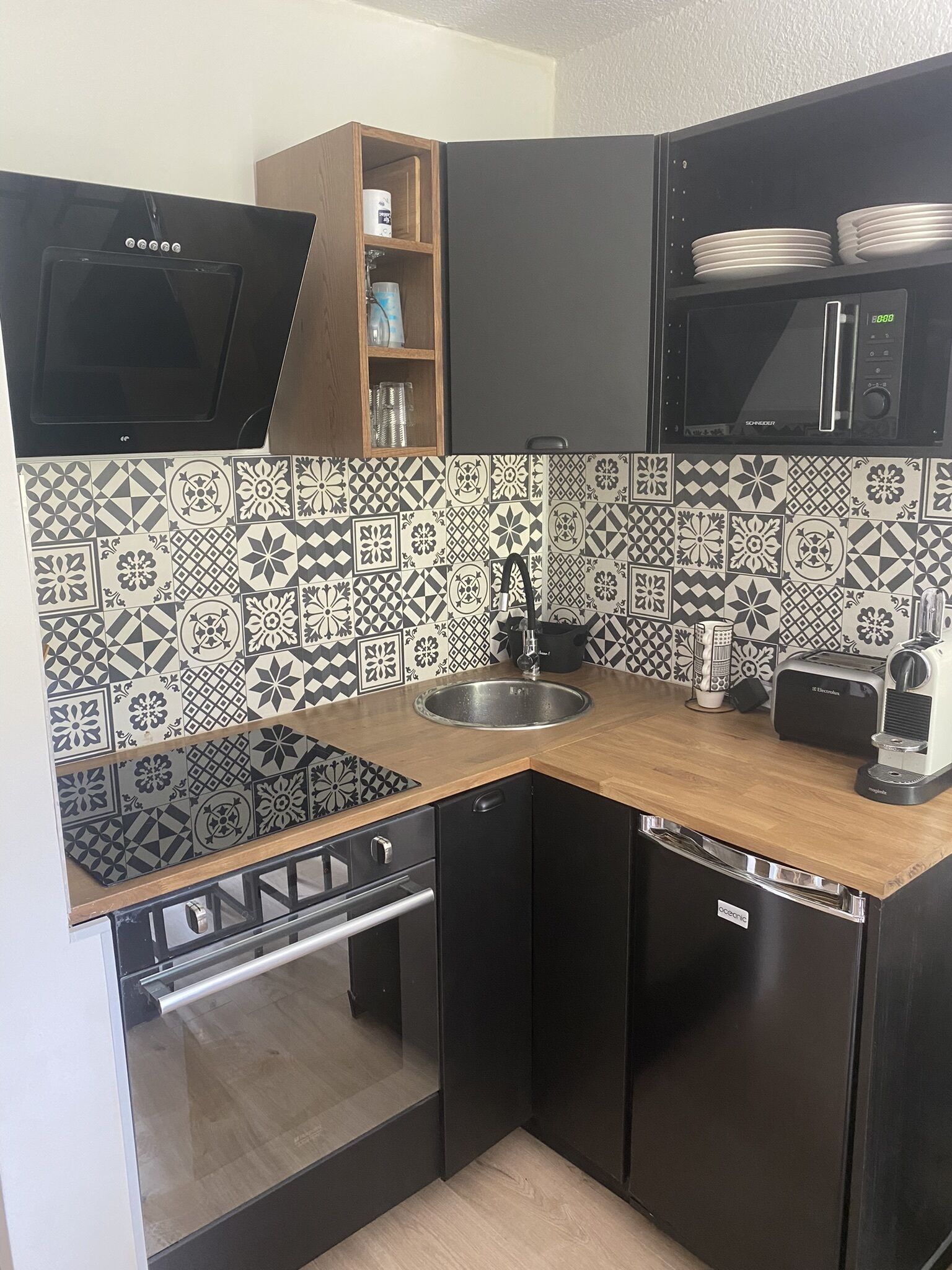 Una cocina compacta equipada con microondas, tostadora, fregadero y lavavajillas.