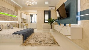 A modern bedroom with a bed, bedside table, and a TV mounted on the wall. - Apartamente Stefan Resort 2 (Navodari)