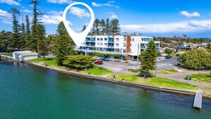 Un hotel moderno frente al agua, con varios balcones y vistas al mar.