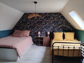 A bedroom with two beds, a patterned wall, a skylight, and a hanging lamp. - Charmant Gîte 6 à 10 Personnes en Bord de mer (Lannion)