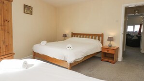 Un dormitorio con cama de madera, mesita de noche, lámpara y armario.