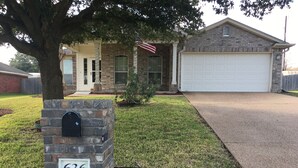A house with a stone mailbox marked 636, a garage, and a lawn. - Perfect home for Baylor, Silos, and Business guests (Hewitt)
