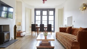 A modern living room with a sofa, a coffee table, and a TV. - 11 Redcliffe Parade (Bristol)