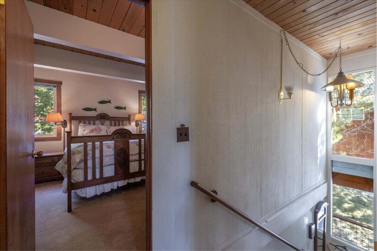 Une chambre à coucher avec un lit en bois, une table de chevet, une lampe et un mur décoré d’autocollants représentant des poissons.