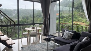 Una sala moderna con un balcón grande, un comedor y una escalera.