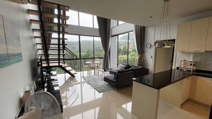 Un apartamento moderno con una escalera, una sala de estar y una cocina.