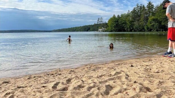 A sandy beach with clear water and a forested shoreline. - Historic Wolfeboro Home one block to Village (Wolfeboro)