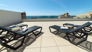 A rooftop terrace with two lounge chairs and a view of the sea. - PREMIUM Apartment with 3 bedrooms. Capacity for 6 people (Marbella)