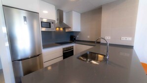 A modern kitchen with stainless steel appliances, a microwave, and a sink. - Deluxe 2 Bedroom Apartment. Capacity for 4 people (Marbella)