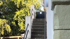 Eine Betontreppe mit Metallgeländern, die zu einer Tür führt.