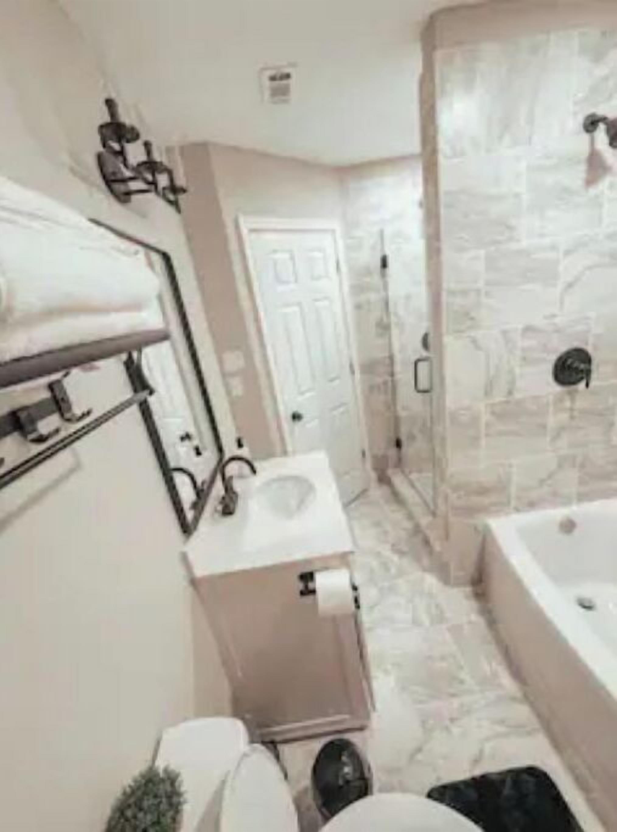 Un baño moderno con ducha de piedra, lavamanos empotrado e inodoro.