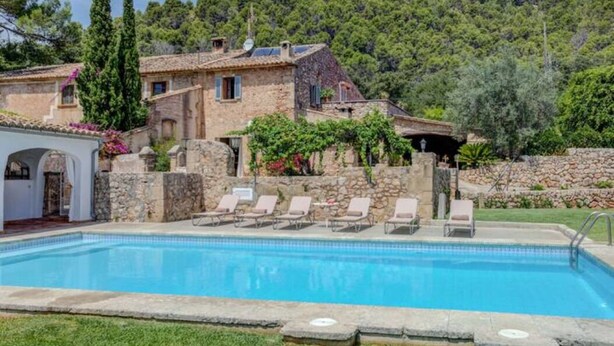 A pool area with lounge chairs and a stone building with a rustic design. - AINA CAN PONTICO Charming villa in Pollença (Pollença)