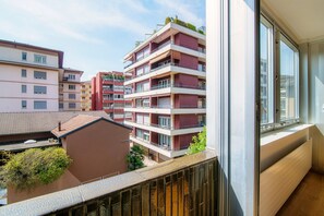 A multi-story residential building with balconies, large windows, and a view of neighboring buildings. - Palace Apartment (Lugano)
