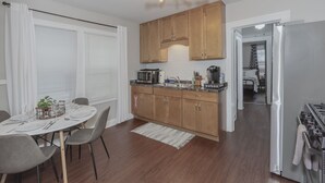 A modern kitchen with wooden cabinets, a built-in microwave, and a stainless steel refrigerator.