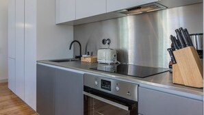 Et moderne køkken med rustfrie stålenheder, en brødrister og et knivdisplay.