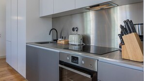 A modern kitchen with stainless steel appliances, a toaster, and a knife block.