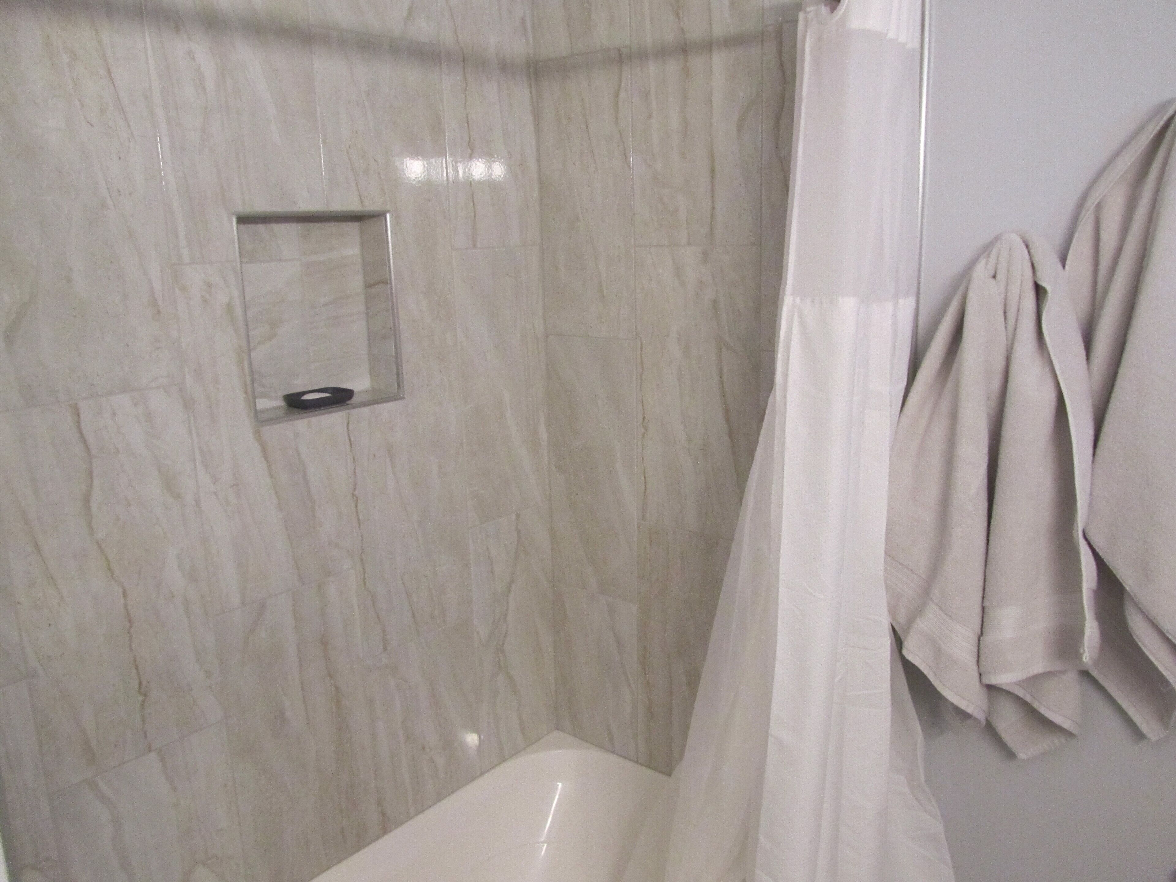 Tina con regadera, secadora de cabello, toallas, jabón 