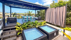 Terraço no telhado com mesa de bilhar, área de estar e banheiras de hidromassagem.