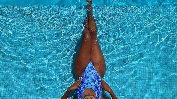 Uma pessoa deitada de costas em uma piscina.