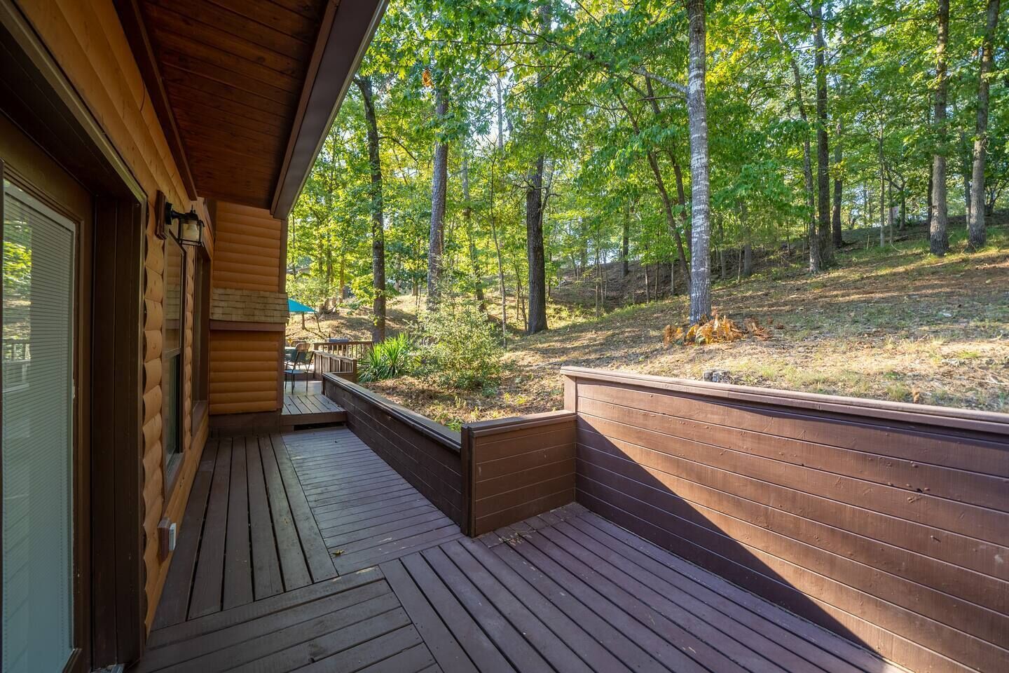 A wooden deck with a view of a forested area.