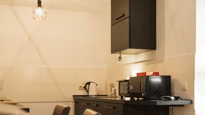 Cozinha compacta com área de jantar, incluindo uma mesa, cadeiras e um pequeno armário.