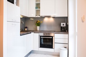Apartamento Deluxe | Cocina privada | Frigorífico, microondas, horno y placa de cocina