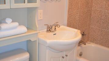 A bathroom with a toilet, sink, and bathtub.