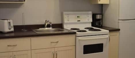 Coffee/tea maker, toaster, cookware/dishes/utensils, dining tables