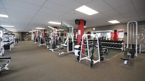 A gym with various exercise equipment, including weight machines, benches, and dumbbells. - Le Citadin (Rouyn-Noranda)